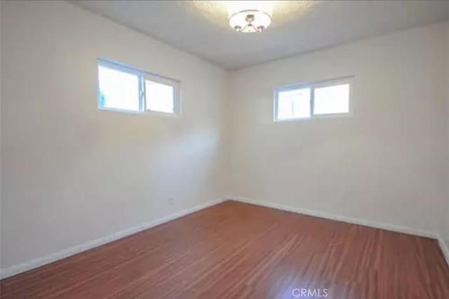 unfurnished room with plenty of natural light and wood-type flooring