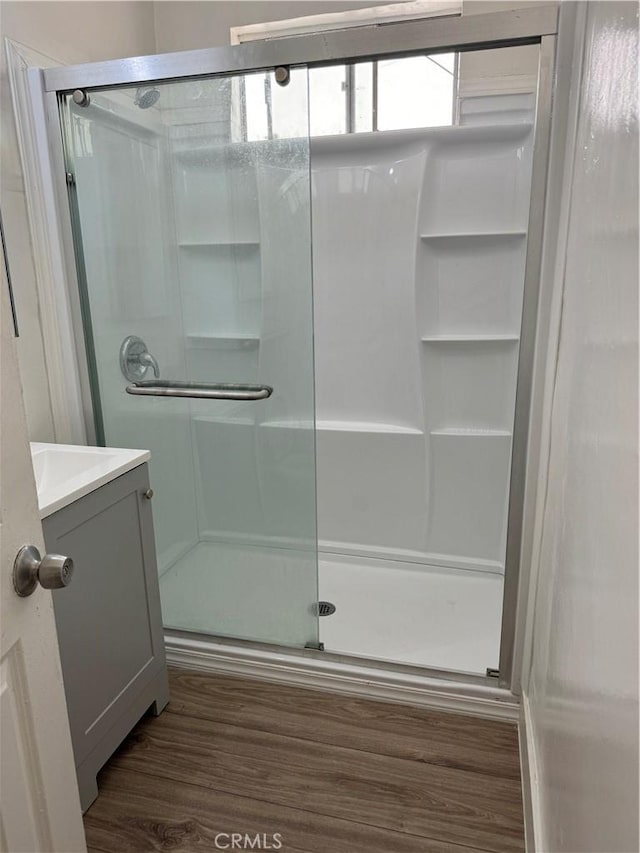 bathroom with hardwood / wood-style floors, vanity, and walk in shower