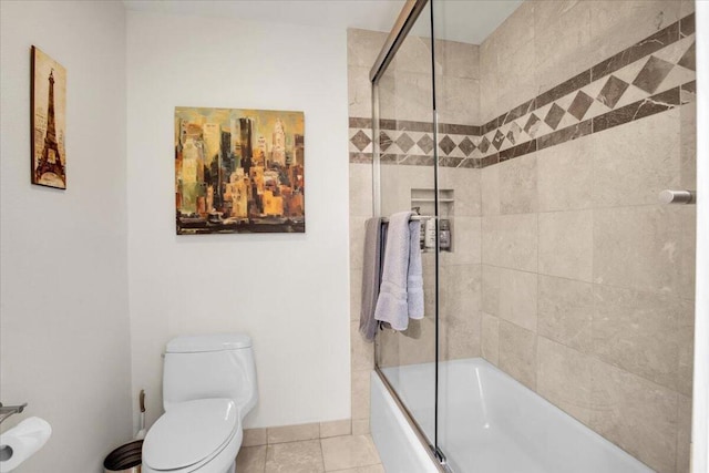 bathroom with toilet, combined bath / shower with glass door, and tile patterned flooring