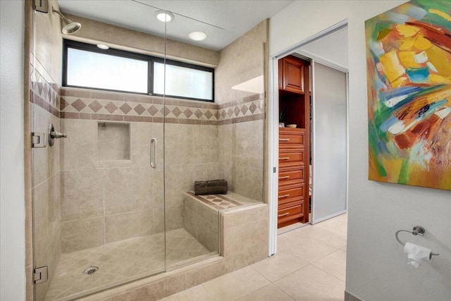 bathroom with a shower with shower door and tile patterned flooring