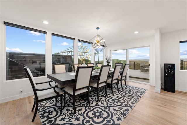 dining area featuring an inviting chandelier, light hardwood / wood-style flooring, and a wealth of natural light