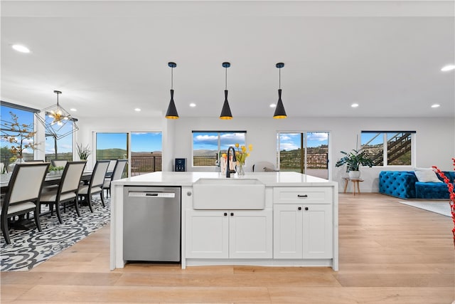 kitchen featuring light wood-type flooring, a kitchen island with sink, sink, white cabinetry, and stainless steel dishwasher