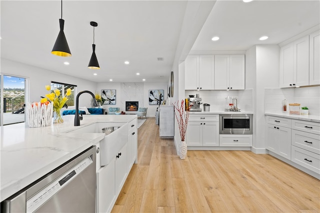 kitchen featuring white cabinetry, light hardwood / wood-style floors, and appliances with stainless steel finishes