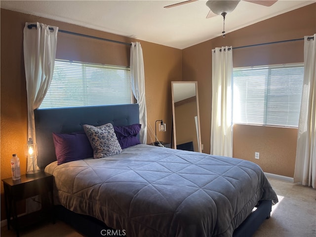 bedroom with carpet, ceiling fan, vaulted ceiling, and multiple windows