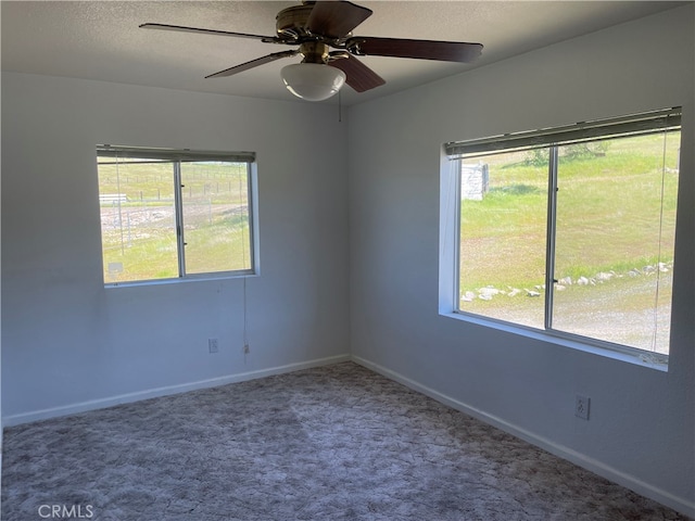 carpeted empty room with ceiling fan and a healthy amount of sunlight