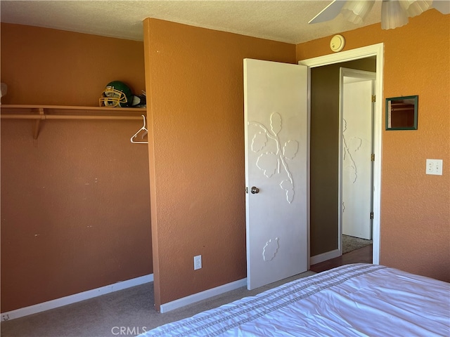 unfurnished bedroom with carpet flooring, a textured ceiling, and ceiling fan