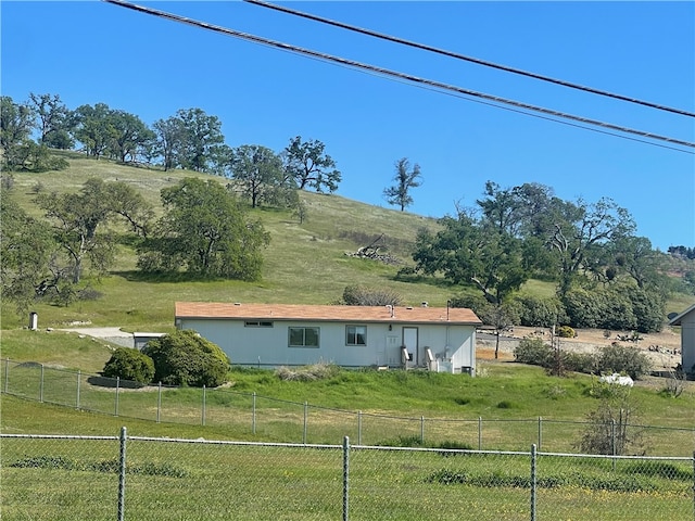 view of home's exterior with a rural view and a lawn