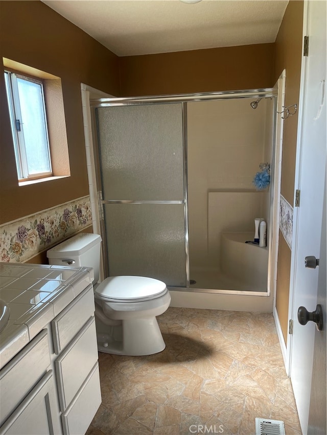 bathroom featuring walk in shower, vanity, and toilet