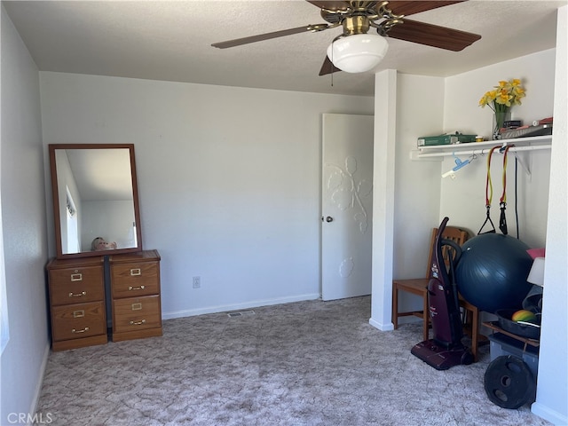 workout room with ceiling fan and light carpet