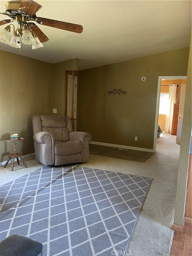 unfurnished living room with ceiling fan and a textured ceiling