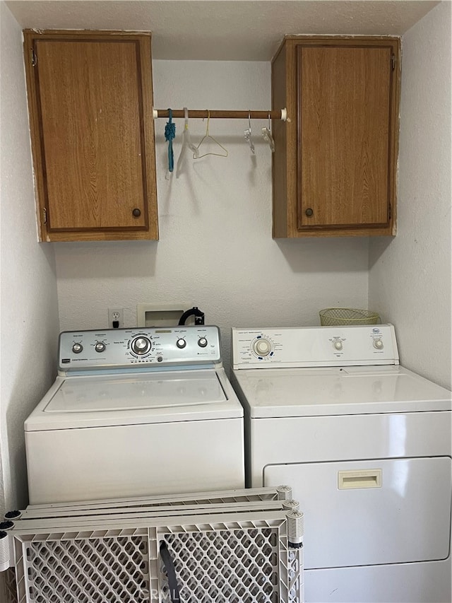 laundry room featuring cabinets and washing machine and dryer