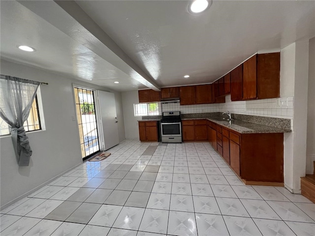 kitchen featuring tasteful backsplash, stainless steel range, and sink