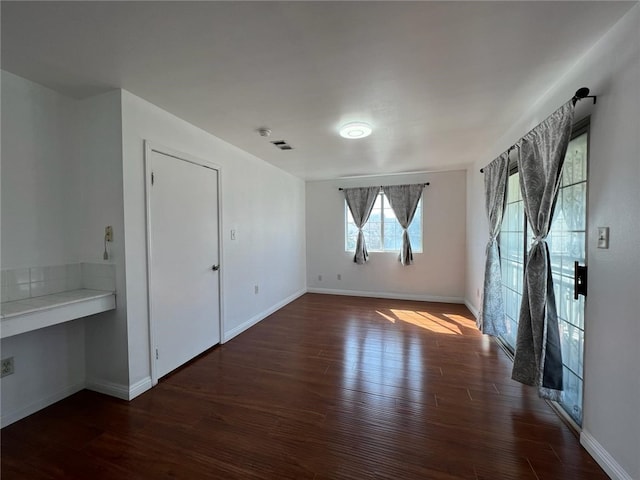 empty room with dark hardwood / wood-style flooring