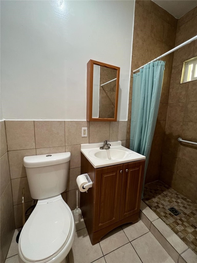 bathroom with vanity, toilet, a shower with shower curtain, and tile walls