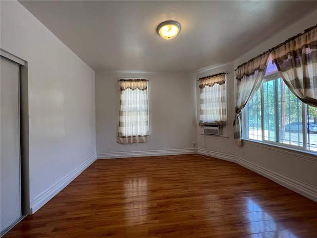 unfurnished room featuring cooling unit and dark hardwood / wood-style flooring