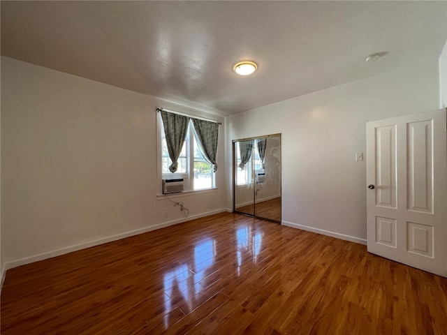 unfurnished room with cooling unit and hardwood / wood-style floors