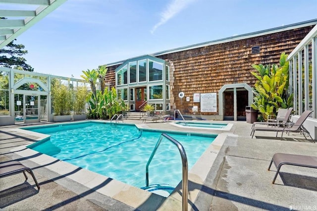 view of pool with a community hot tub and a patio area