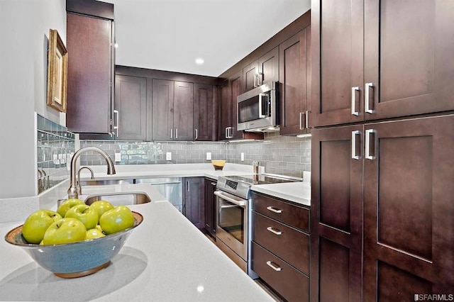 kitchen featuring dark brown cabinets, sink, appliances with stainless steel finishes, and tasteful backsplash