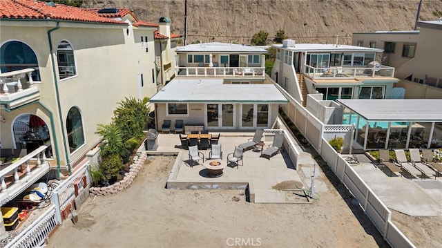 rear view of house featuring an outdoor living space with a fire pit