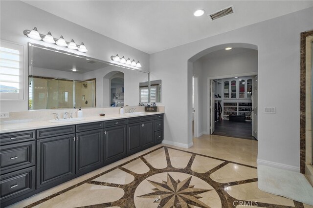 bathroom with vanity and a shower with door