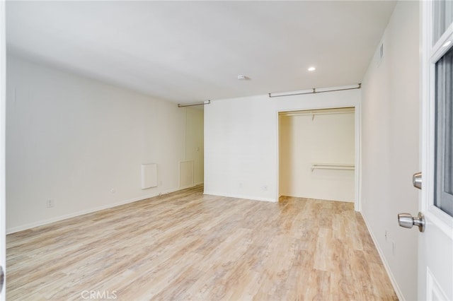 unfurnished bedroom featuring light hardwood / wood-style floors and a closet