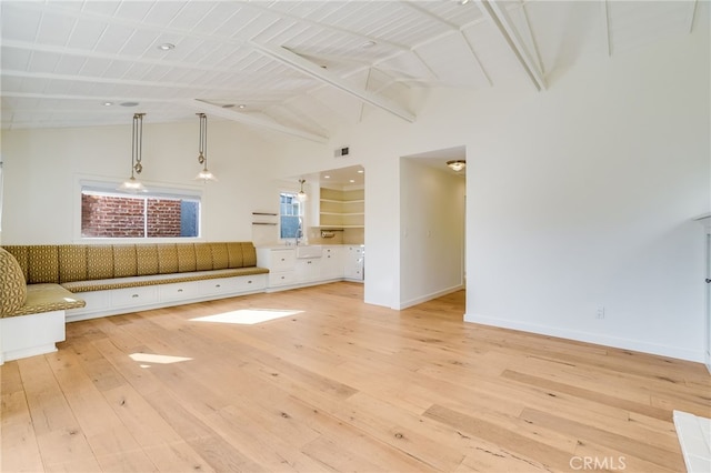 unfurnished living room featuring beam ceiling, light wood-type flooring, high vaulted ceiling, and wood ceiling