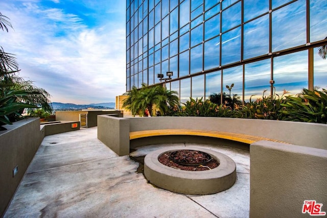 patio terrace at dusk featuring a fire pit