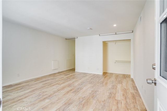 unfurnished bedroom with a closet and light wood-type flooring