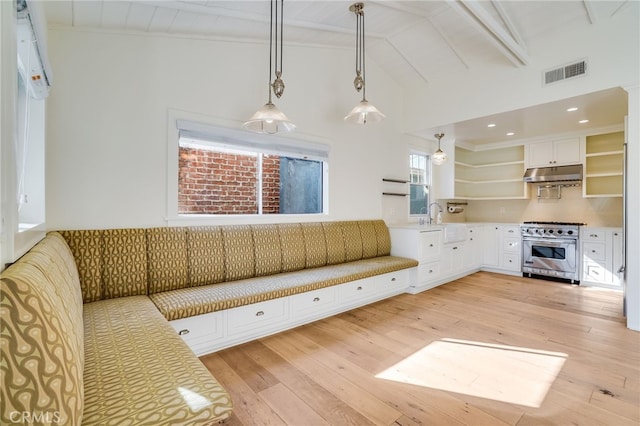 unfurnished living room featuring beamed ceiling, light hardwood / wood-style floors, high vaulted ceiling, and sink