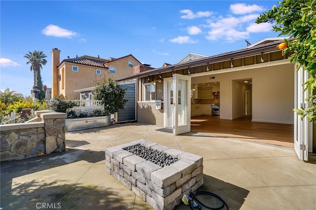 back of property featuring a patio and an outdoor fire pit