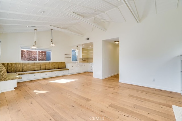 unfurnished living room featuring beamed ceiling, high vaulted ceiling, light wood-type flooring, and wood ceiling