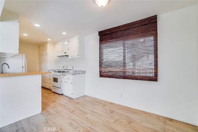 kitchen featuring white appliances, light hardwood / wood-style floors, white cabinetry, and sink