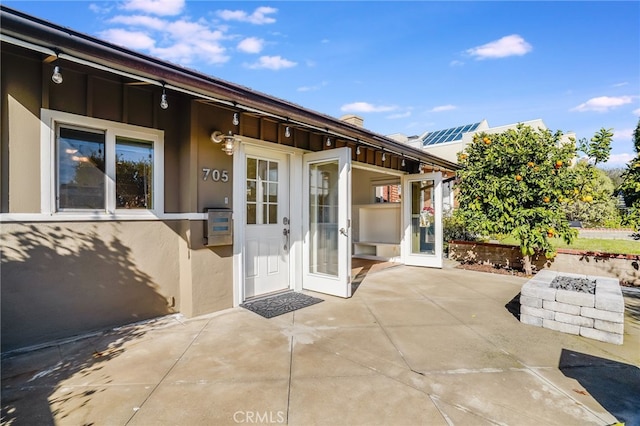 view of exterior entry with a patio