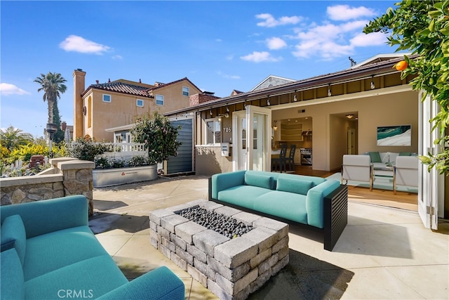 view of patio featuring an outdoor living space with a fire pit