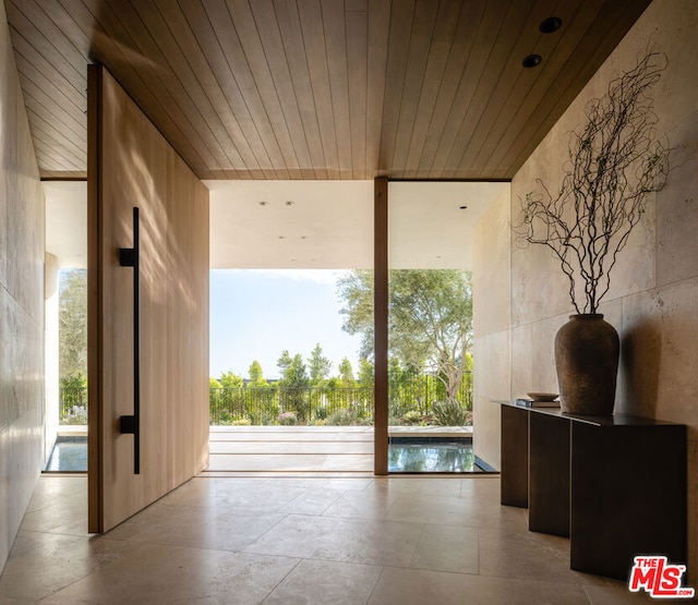 living room with light tile flooring, expansive windows, and wooden ceiling