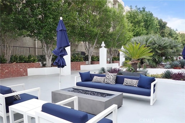 view of patio / terrace featuring an outdoor living space with a fire pit and fence