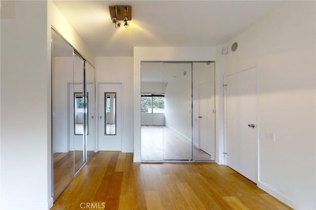 interior space featuring multiple closets and light wood-style flooring