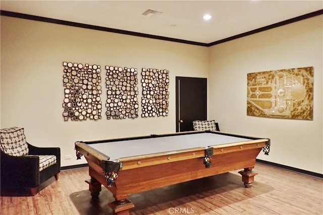 recreation room with ornamental molding, visible vents, baseboards, and wood finished floors