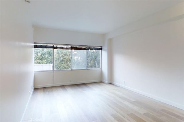 empty room with light wood-style floors and baseboards