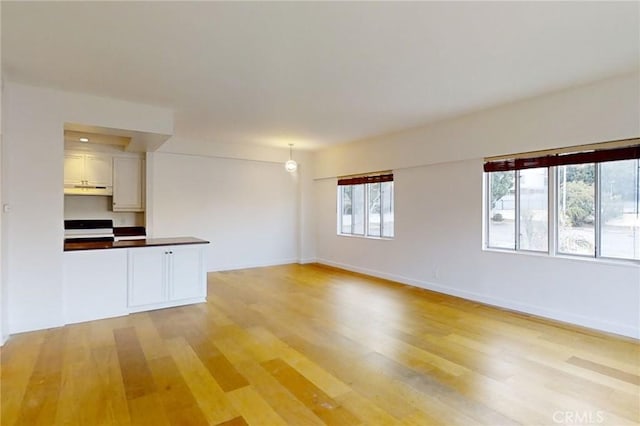 unfurnished living room featuring light wood-style floors and baseboards