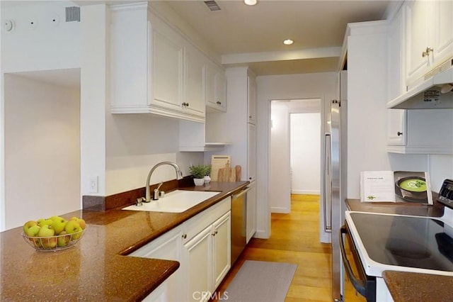 kitchen featuring stainless steel appliances, a sink, white cabinetry, and under cabinet range hood