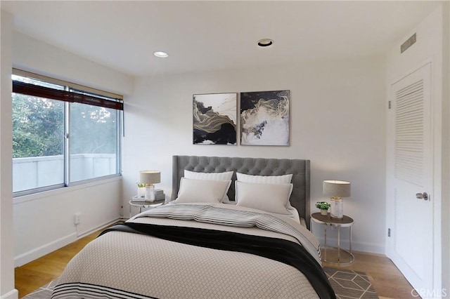 bedroom featuring visible vents, baseboards, wood finished floors, and recessed lighting