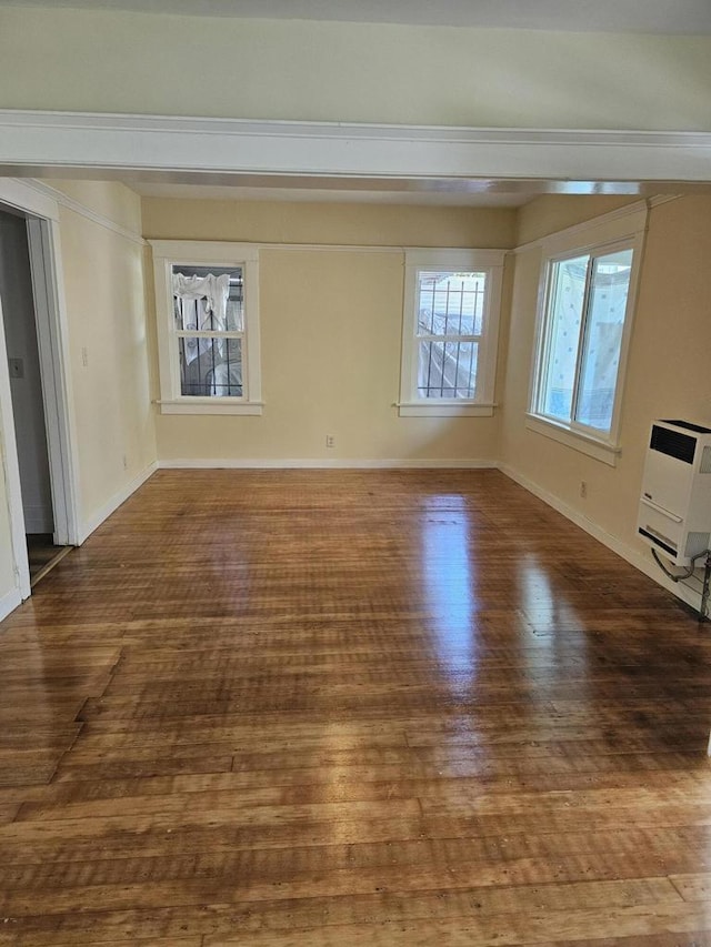 unfurnished room with heating unit and hardwood / wood-style floors