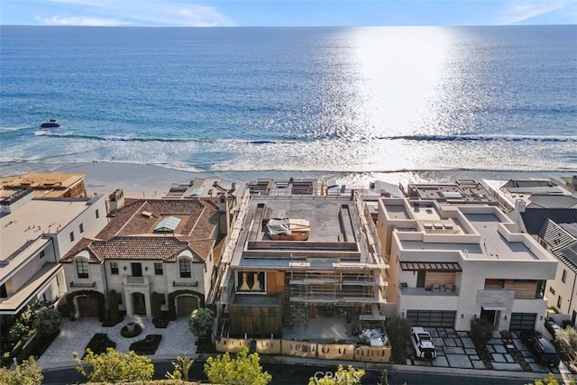 birds eye view of property with a water view and a beach view