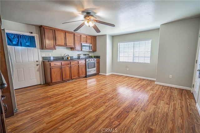 kitchen featuring ceiling fan, sink, wood-type flooring, and stainless steel appliances