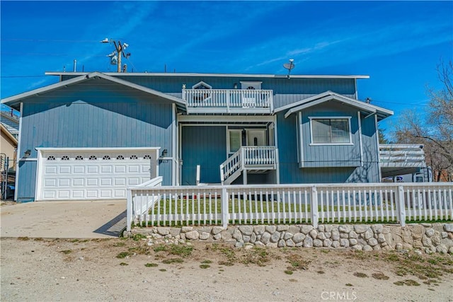 front of property with covered porch, a balcony, and a garage