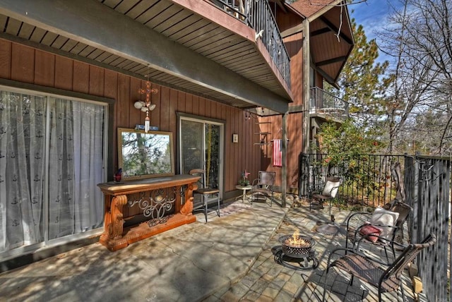 view of patio / terrace featuring a fire pit and a balcony