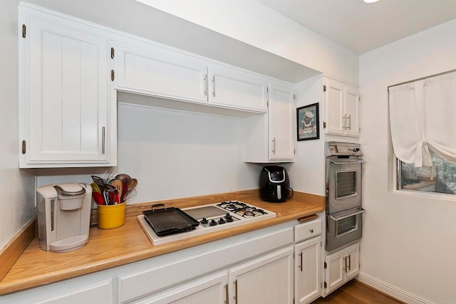 kitchen featuring white cabinetry, white gas cooktop, and dark wood-type flooring