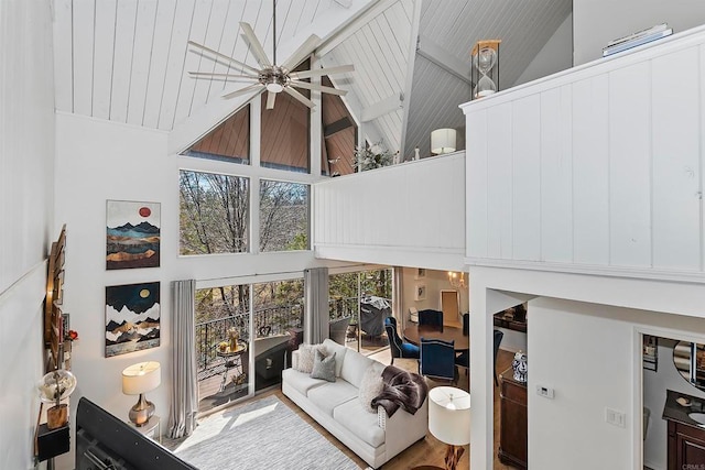 living room with wooden ceiling, hardwood / wood-style flooring, ceiling fan, and high vaulted ceiling