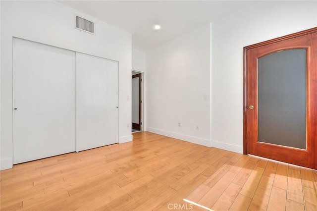 unfurnished bedroom featuring light wood-type flooring and a closet